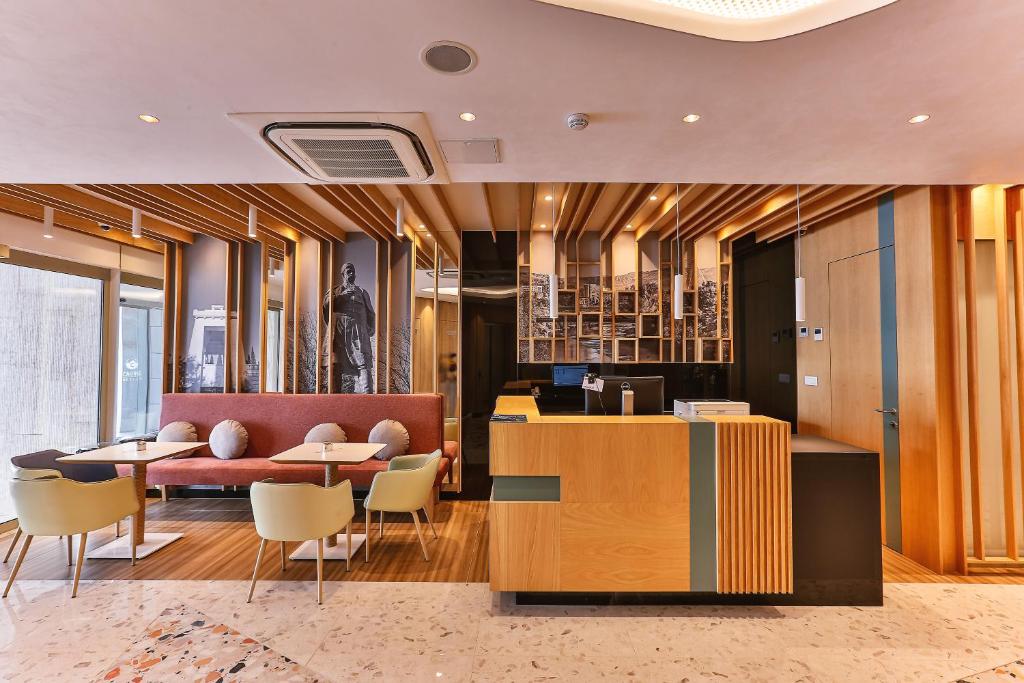 a lobby with tables and chairs in a building at Carine Hotel Centar in Podgorica