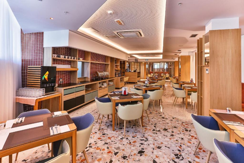 un ristorante con tavoli e sedie in una stanza di Carine Hotel Centar a Podgorica