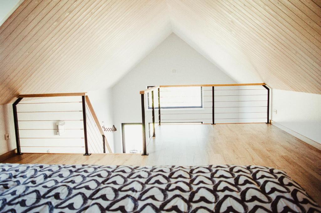 an attic room with a bed and a staircase at Beach House Kaltene in Kaltene