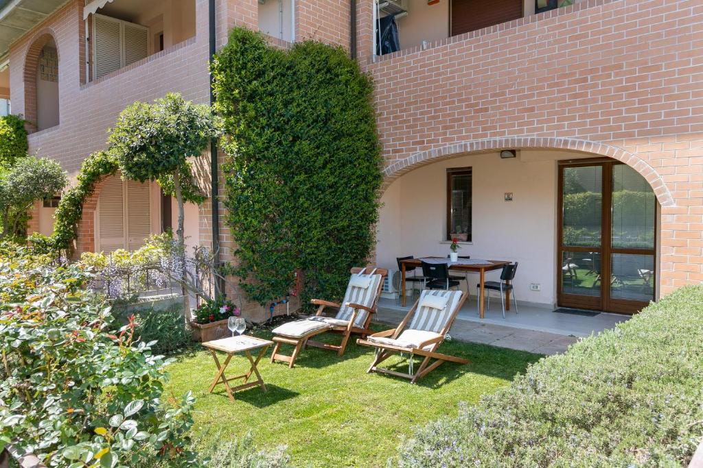 un patio avec des chaises et une table en face d'un bâtiment dans l'établissement Residence Valle Fiorita, à Piombino