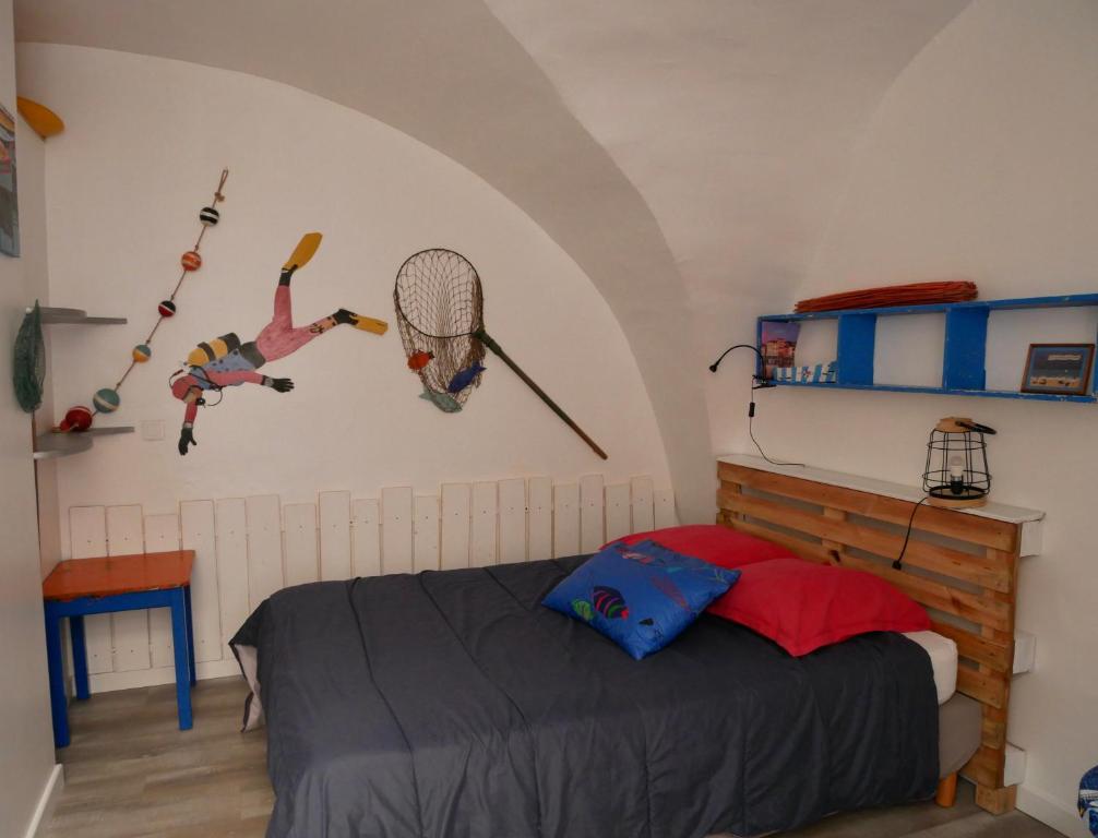 a bedroom with a bed and a wall with a wall with hockey players at Le Biou in Cassis