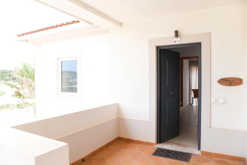 a hallway of a house with a black door at Casa Moana in Casal da Lagoa Seca