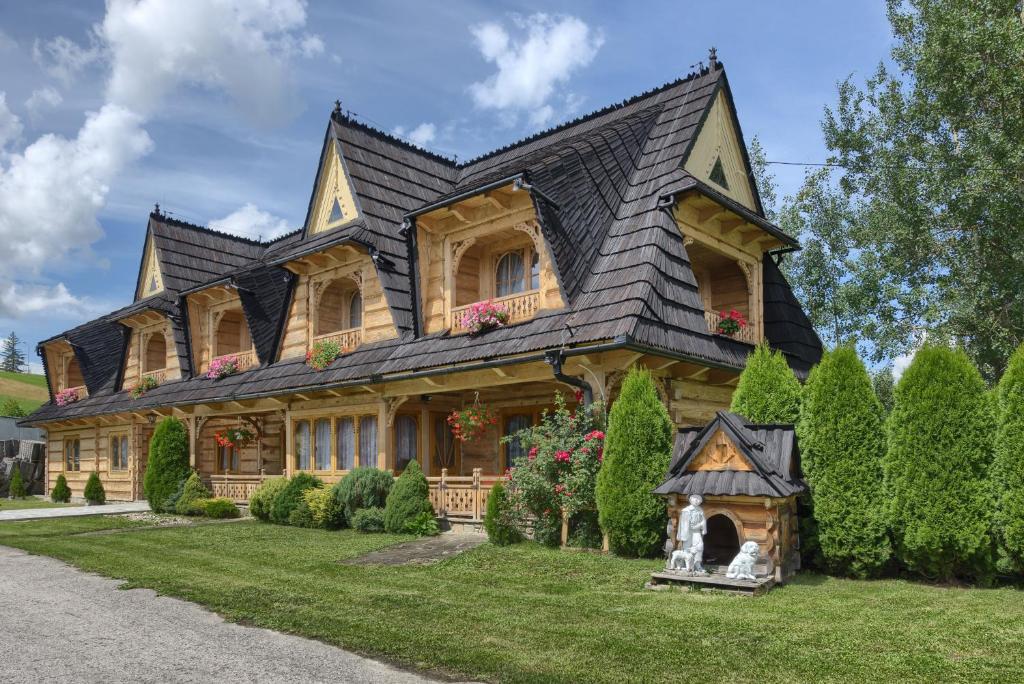 a large wooden house with a black roof at Góralska rezydencja in Witów