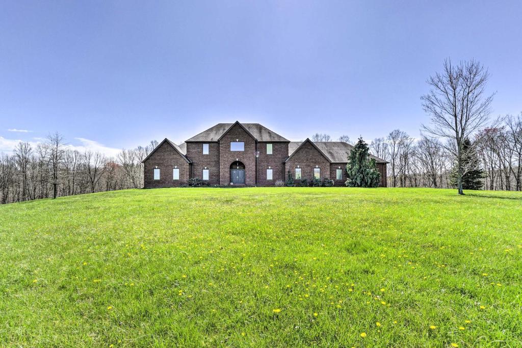 a large house on a hill with a green field at Vast McArthur Home Near Wayne National Forest in Hamden