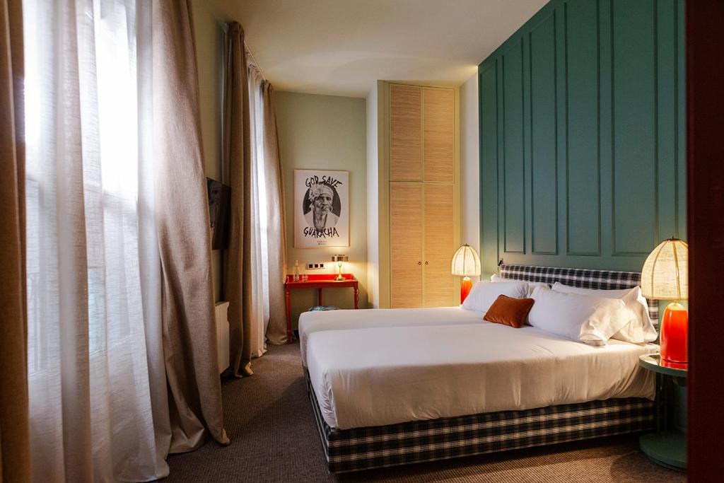 sypialnia z łóżkiem i zieloną ścianą w obiekcie chic&basic Habana Hoose w Barcelonie