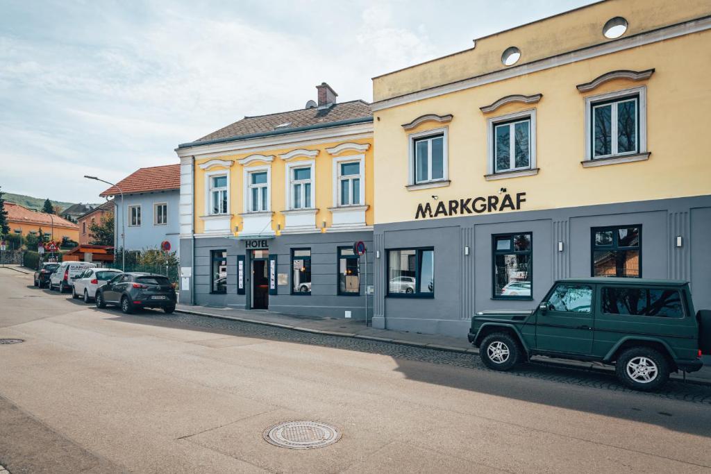 a building with a car parked in front of a street at Hotel Markgraf in Klosterneuburg