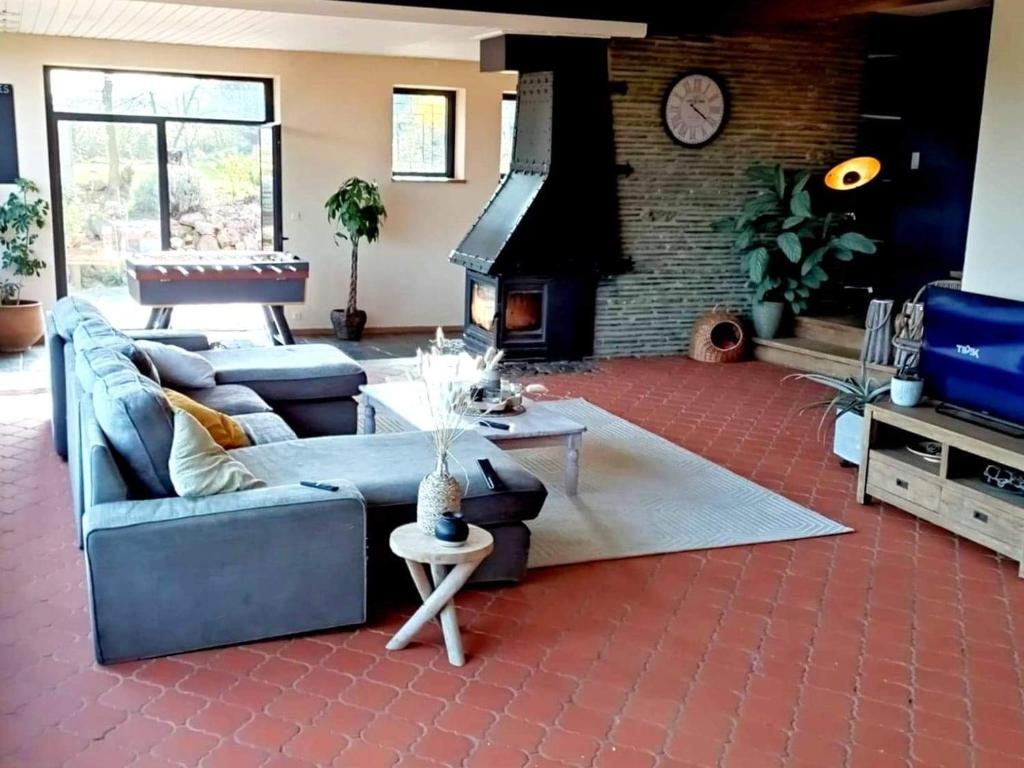 a living room with a couch and a fireplace at Villa Viveye in Ferrières