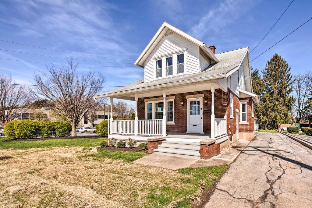 a brick house with a white door on a street at Bright and Sunny Abode, 2 Mi to Hersheypark! in Hershey