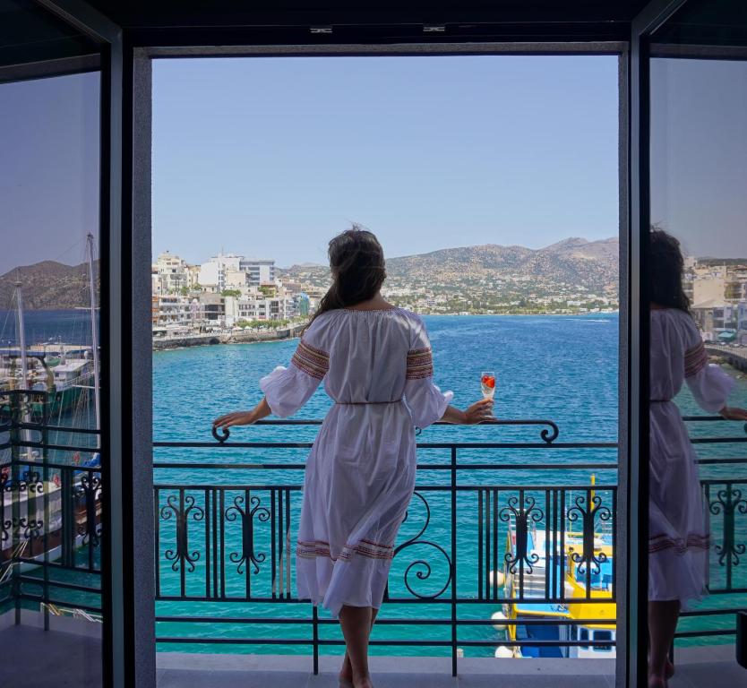 アギオス・ニコラオスにあるCasa Porto Boutique Hotel - Adults onlyの二人の女性が水辺を見渡すバルコニーに立っている