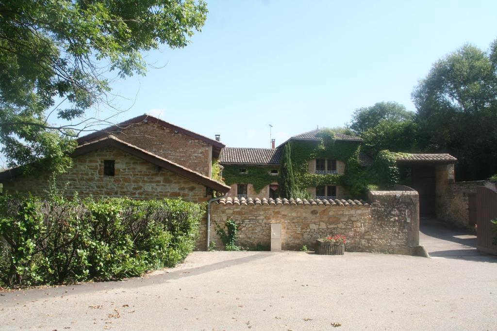 una gran casa de piedra con una entrada delante de ella en L'Aube du Moulin en Gleizé