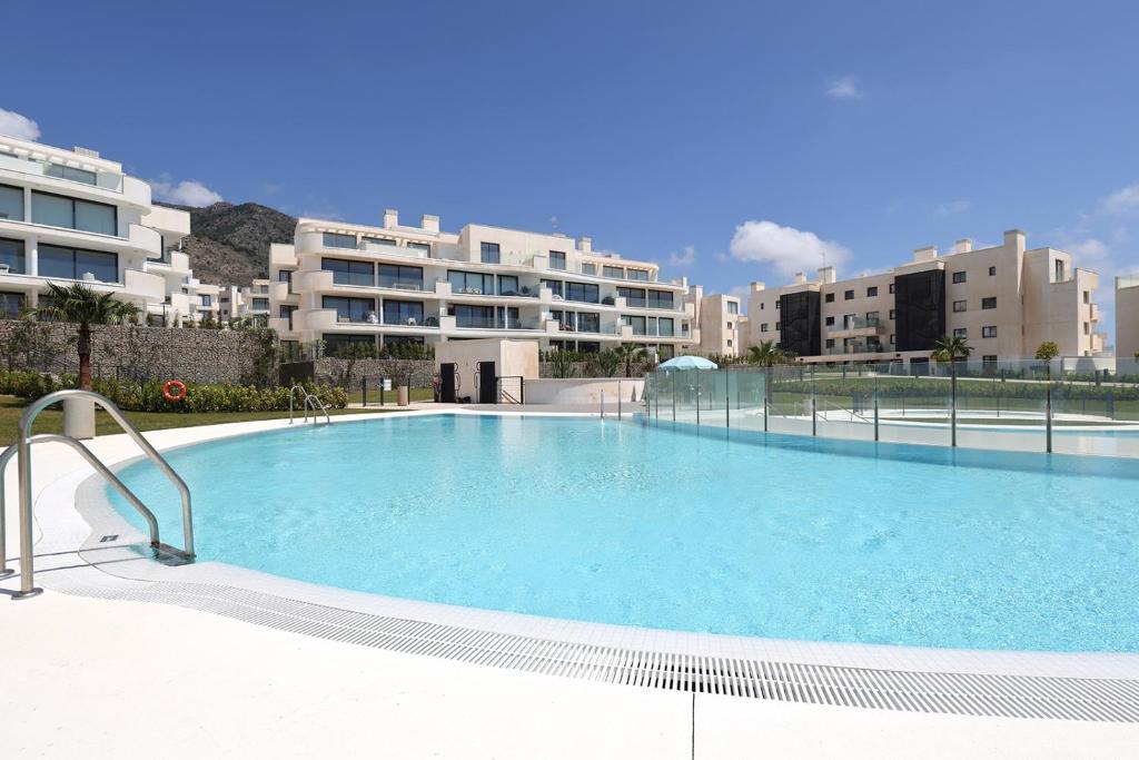 een groot zwembad voor sommige gebouwen bij 092 - Ultra Modern, Spacious Apartment With Private Garden & BBQ in Málaga