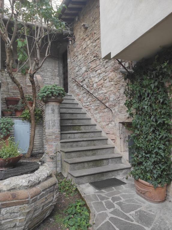 un escalier en pierre menant à un bâtiment en briques dans l'établissement All'Archetto del Terz'Ordine, à Assise