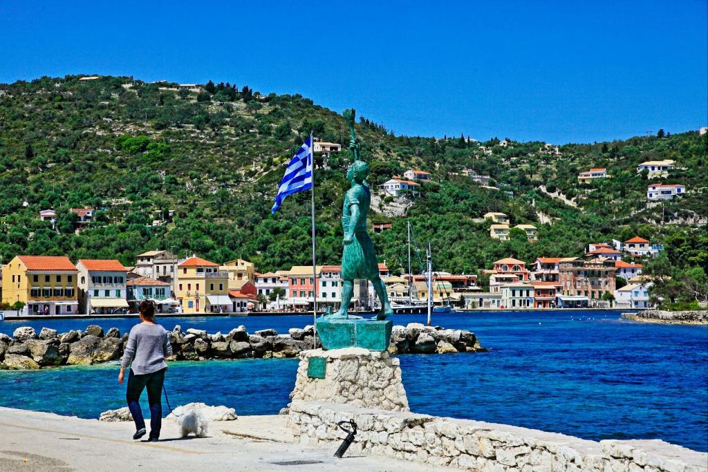 a woman standing next to a statue next to the water at Villa Katerini in Gaios