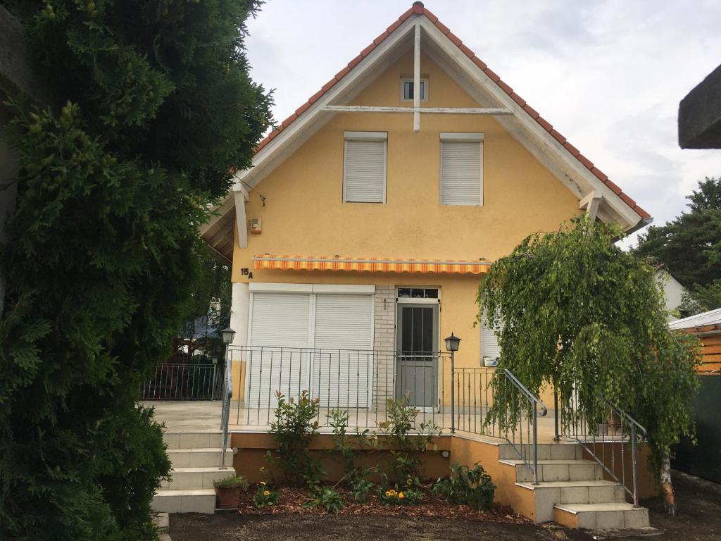a yellow house with a gate in front of it at Sunhouse, Balatonvilágos in Balatonvilágos