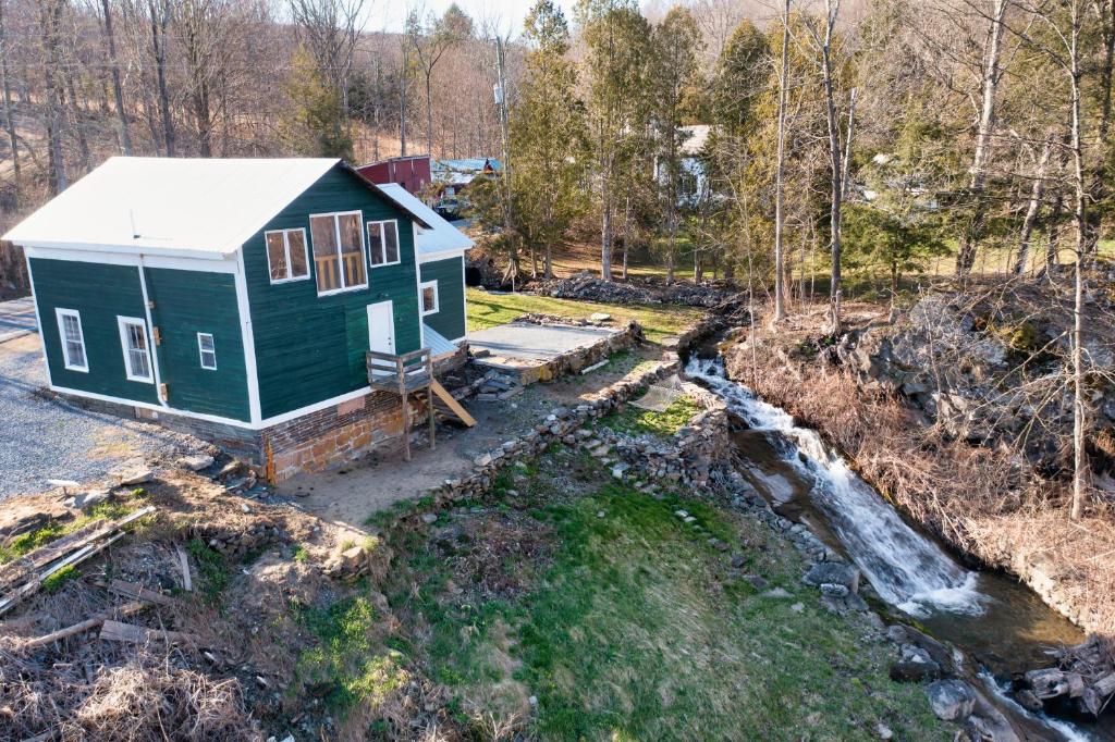 an aerial view of a green tiny house next to a stream at Cottage on the Creek in Salem