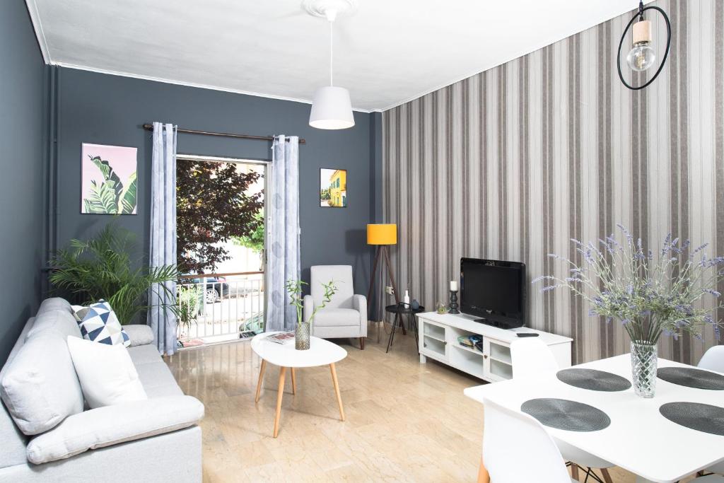 uma sala de estar com um sofá branco e uma televisão em Malvina's Dream - Comfort and style-Central Aigio em Aigio