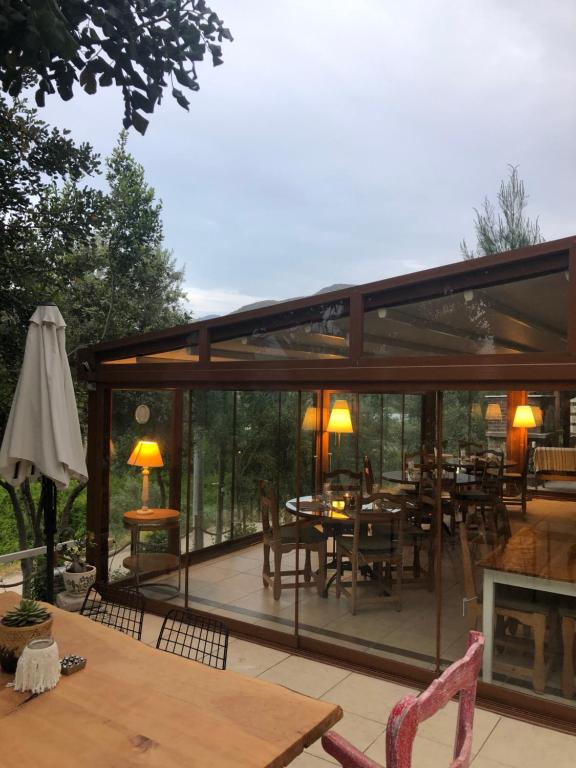 a conservatory with a table and chairs and a fireplace at Swiss Eviniz Hotel in Adrasan