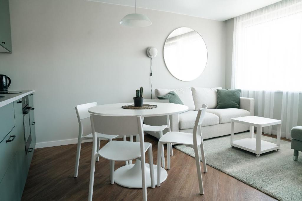 ein Wohnzimmer mit einem Tisch und einem weißen Sofa in der Unterkunft Grey Green Cozy Apartment in Birštonas