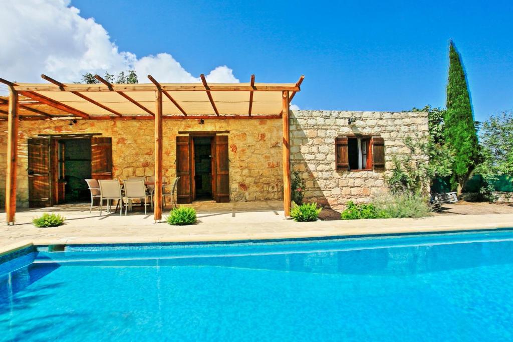 a house with a swimming pool in front of a building at Simeon Estate in Drousha