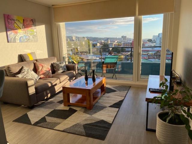 sala de estar con sofá y mesa de centro en Departamento Amoblado con excelente ubicación en Concepción