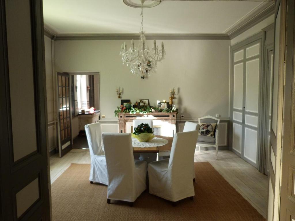 comedor con mesa, sillas y lámpara de araña en Le Clos Notre Dame B&B, en Mareuil