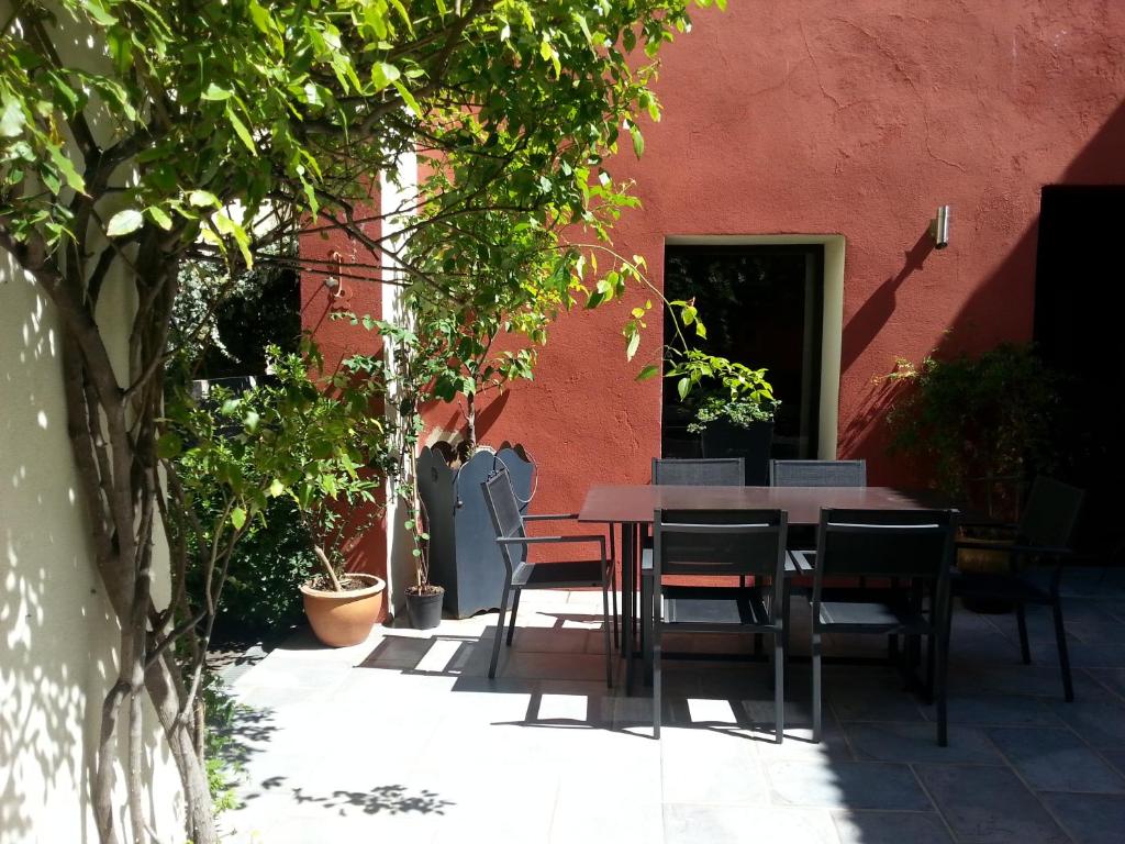 a table and chairs in front of a red building at Les Chambres de l'Abbaye in Marseille