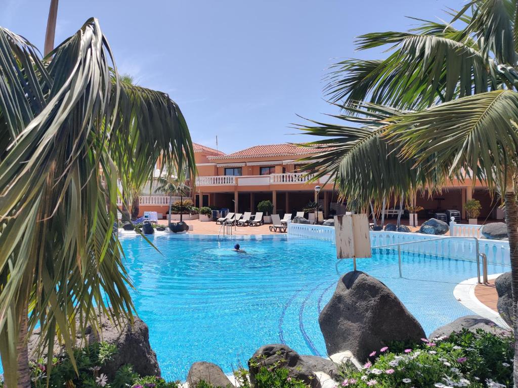 una piscina con palme e un resort di Seafront Royal Garden Mile a Playa de las Americas