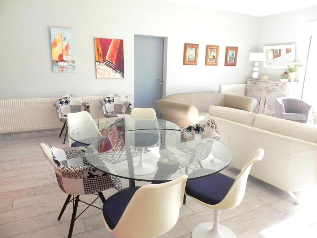a living room with a glass table and chairs at Appartement de 3 chambres a Les Sables d&#39;Olonne a 800 m de la plage avec wifi in Les Sables-d&#39;Olonne