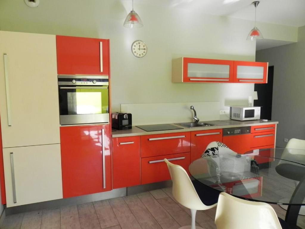 a kitchen with red cabinets and a glass table at Appartement de 3 chambres a Les Sables d&#39;Olonne a 800 m de la plage avec wifi in Les Sables-d&#39;Olonne