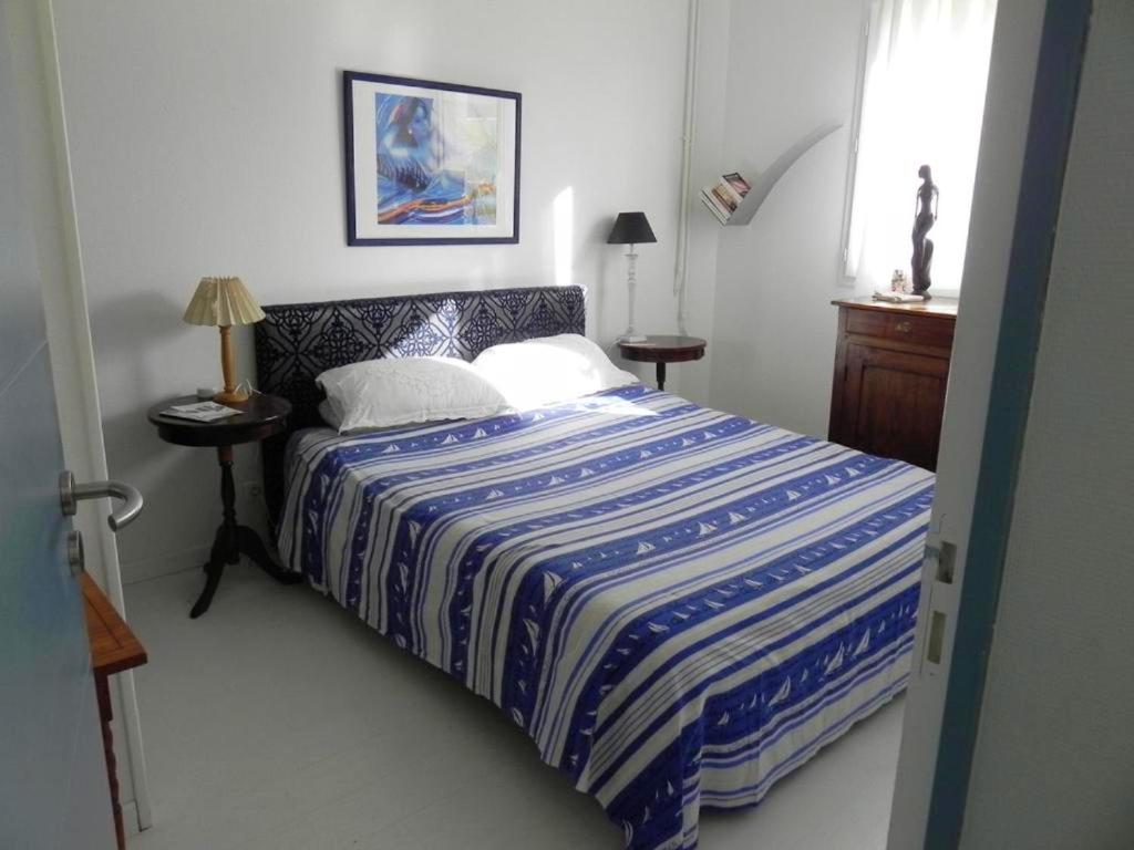 a bedroom with a bed with a blue and white comforter at Appartement de 3 chambres a Les Sables d&#39;Olonne a 800 m de la plage avec wifi in Les Sables-d&#39;Olonne