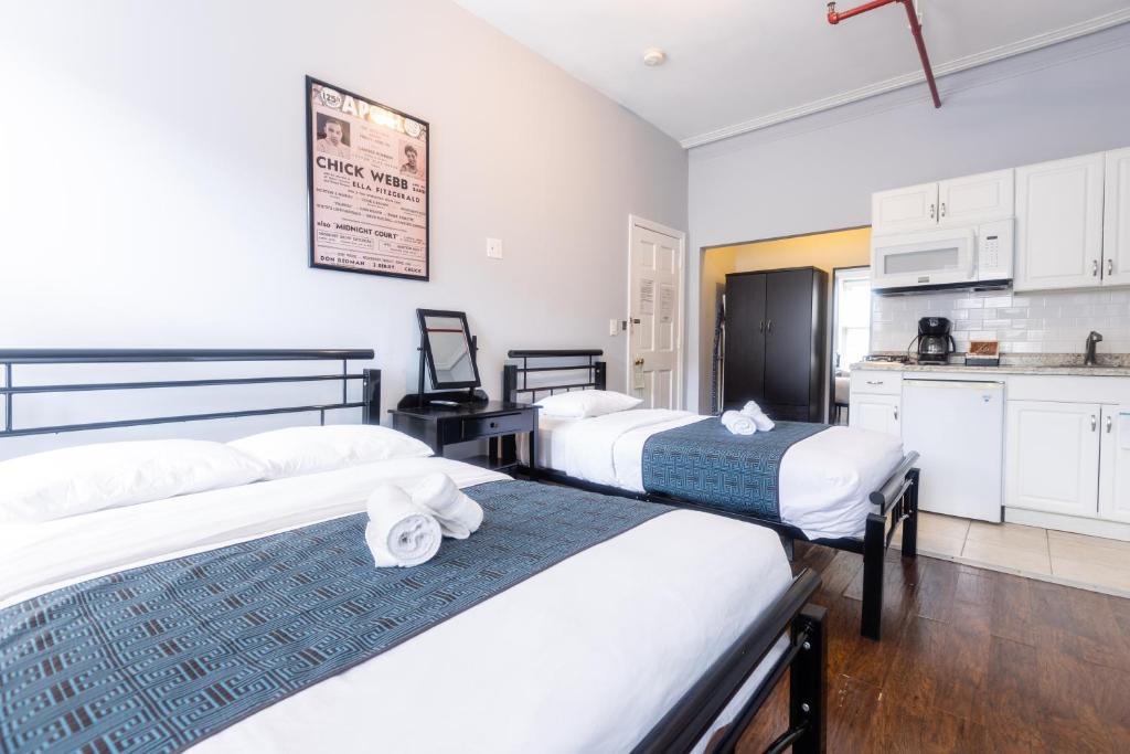 a bedroom with two beds and a kitchen with a counter at The Central Park North in New York