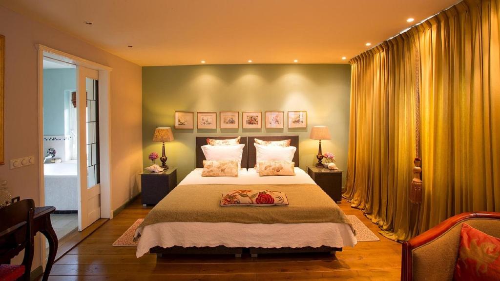 a bedroom with a large bed and yellow curtains at B&B lux Schijndel in Schijndel