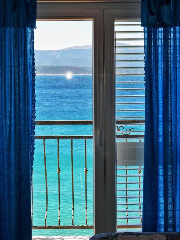 a view of the ocean from a bedroom window at Apartmani Robert in Bol