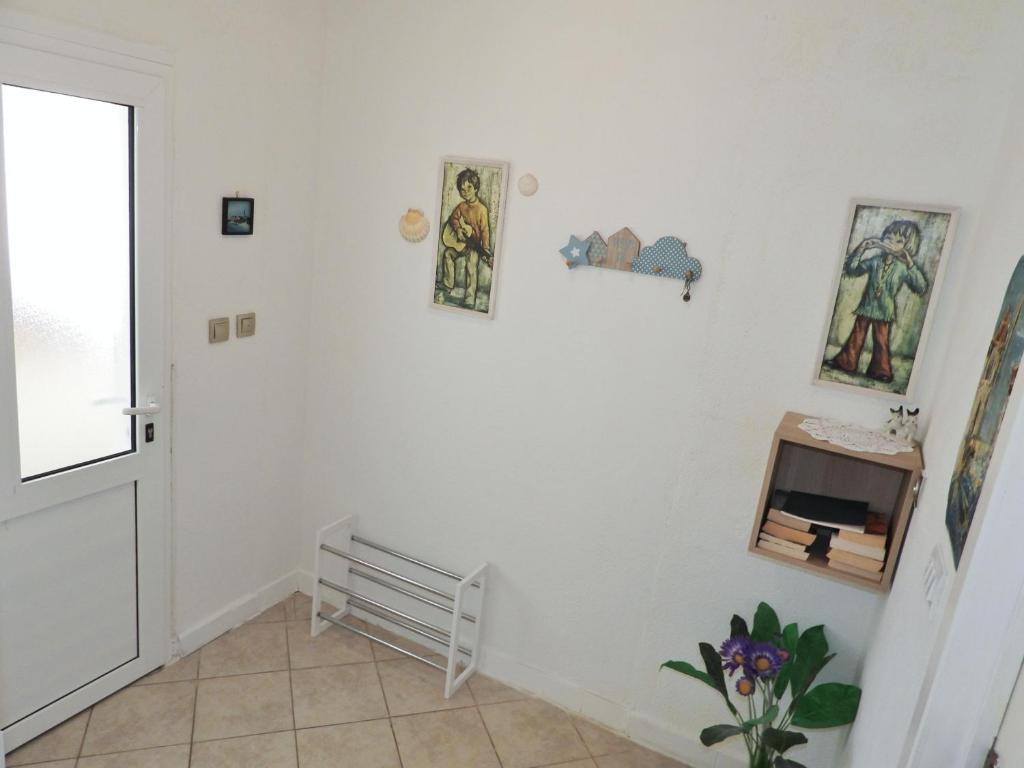 a hallway with a white wall with pictures on it at Apartmani Robert in Bol