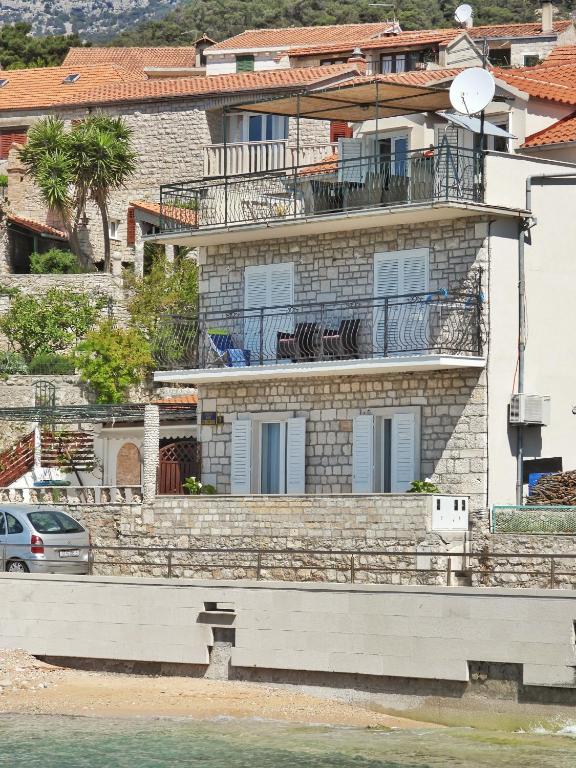 a building with a balcony on top of it at Apartmani Robert in Bol