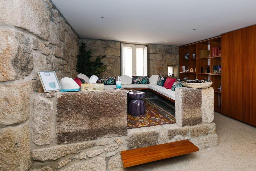 a living room with a stone wall at Casa do Passadiço - Alvarenga in Alvarenga