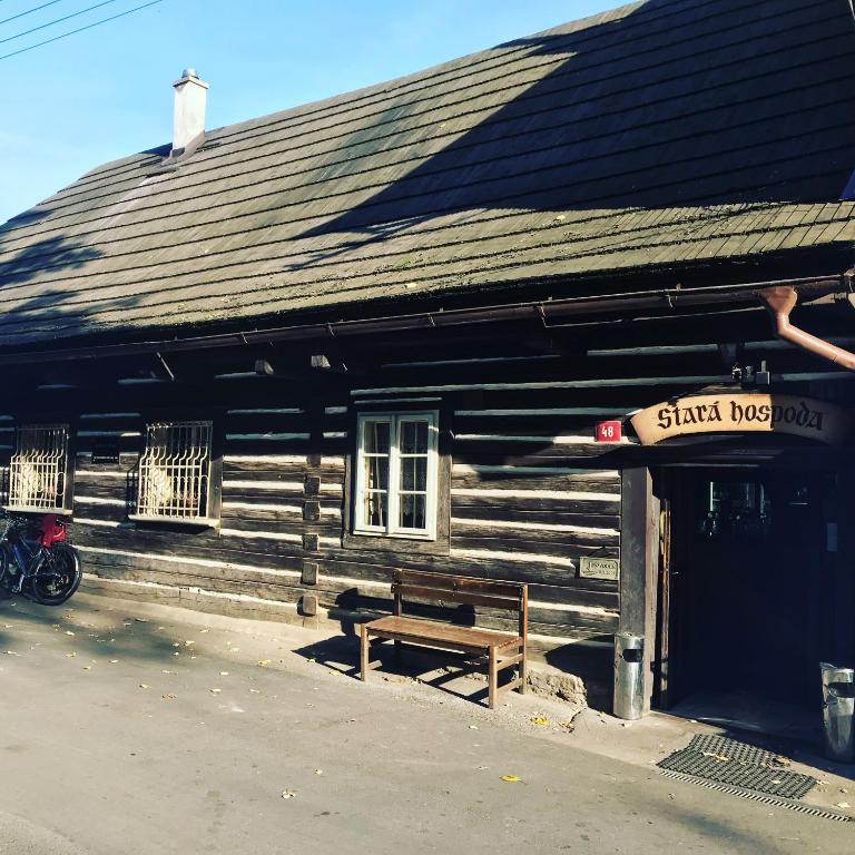 a wooden building with a bench in front of it at Pension Stará hospoda in Dobřív