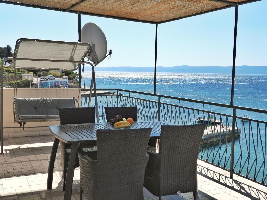 a table and chairs on a balcony with the ocean at Apartmani Robert in Bol