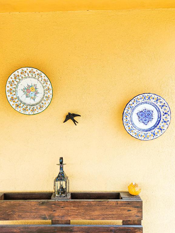 three plates on a wall with a bird on the wall at Quinta dos Padrinhos - Suites in the Heart of the Douro in Lamego