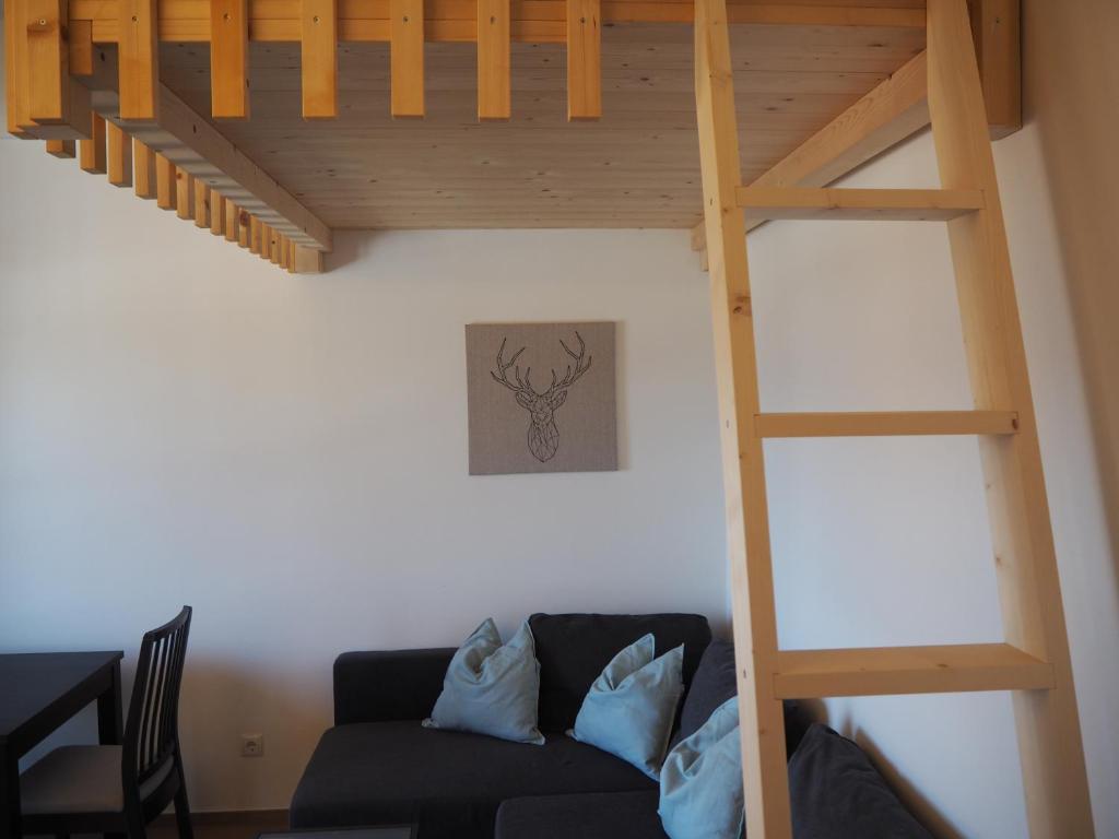 salon z łóżkiem na podwyższeniu i kanapą w obiekcie Ebner Appartements w mieście Aldino