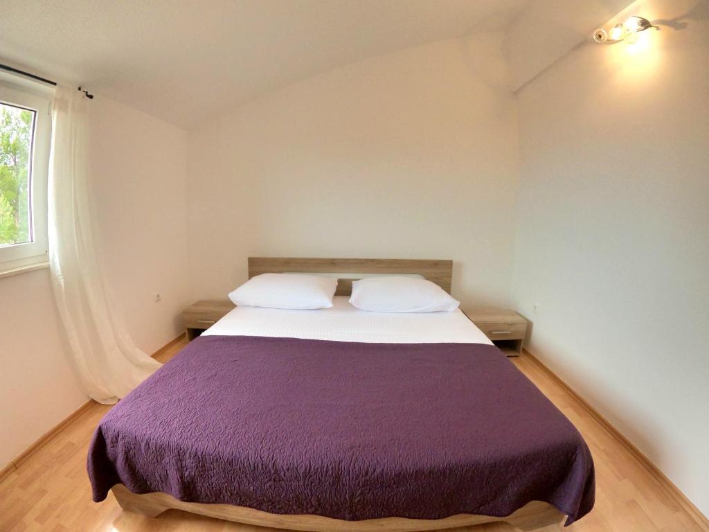 a bedroom with a large bed with a purple blanket at Luxury lifestyle apartment in Podstrana