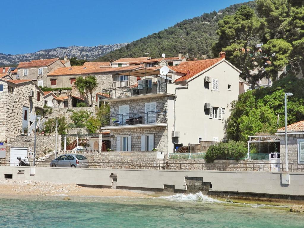 a house on the shore of a body of water at Apartmani Robert in Bol