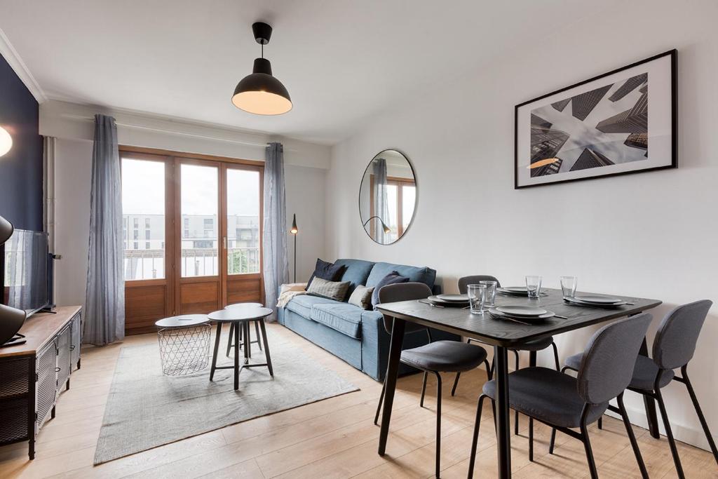 uma sala de estar com um sofá azul e uma mesa em Superbe Appartement de standing au cœur de Lille em Lille