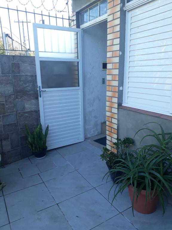 une porte de garage avec des plantes devant un bâtiment dans l'établissement APARTAMENTOS POR DIÁRIA Av DOMINGOS DE ALMEIDA, à Pelotas