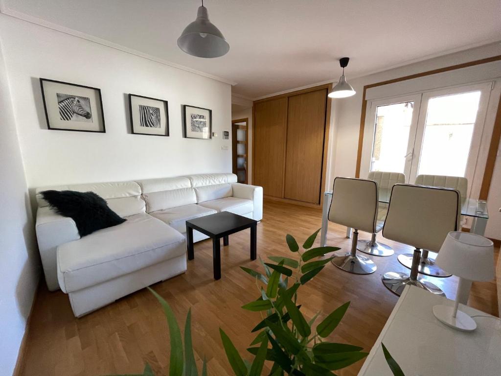 sala de estar con sofá blanco y mesa en Apartamento a 5 min caminando de la Playa Sta. Cristina, Oleiros (Terraza, Parkin, ), en Oleiros