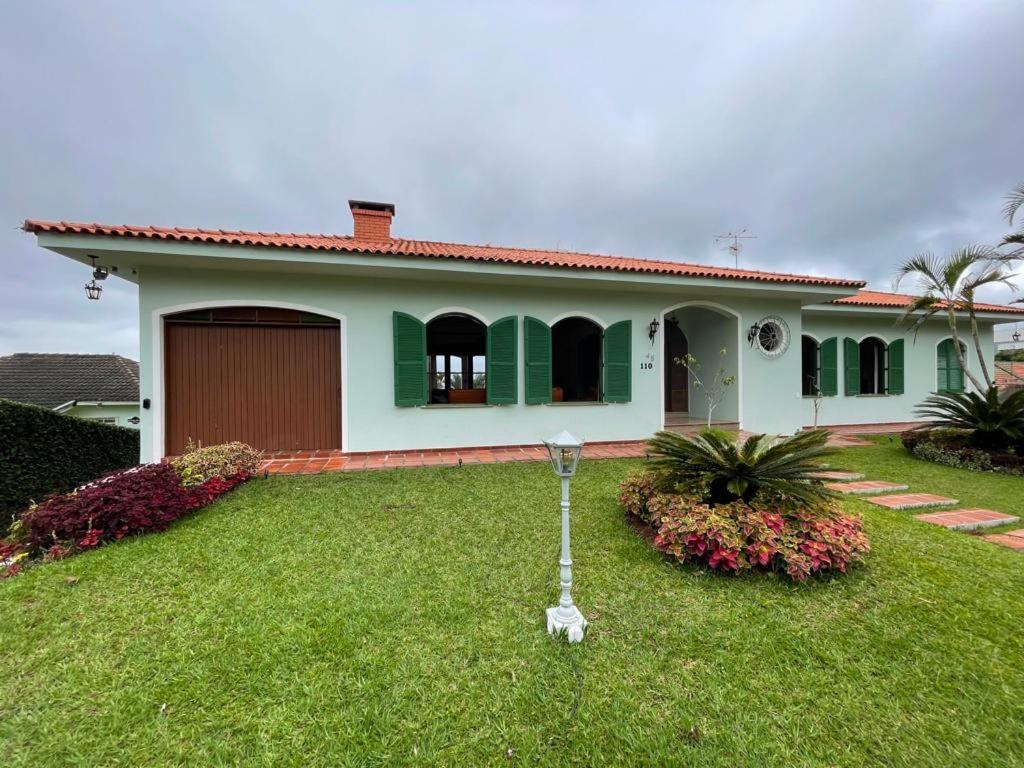dom z trawnikiem przed nim w obiekcie Dom Ravello w mieście Telêmaco Borba