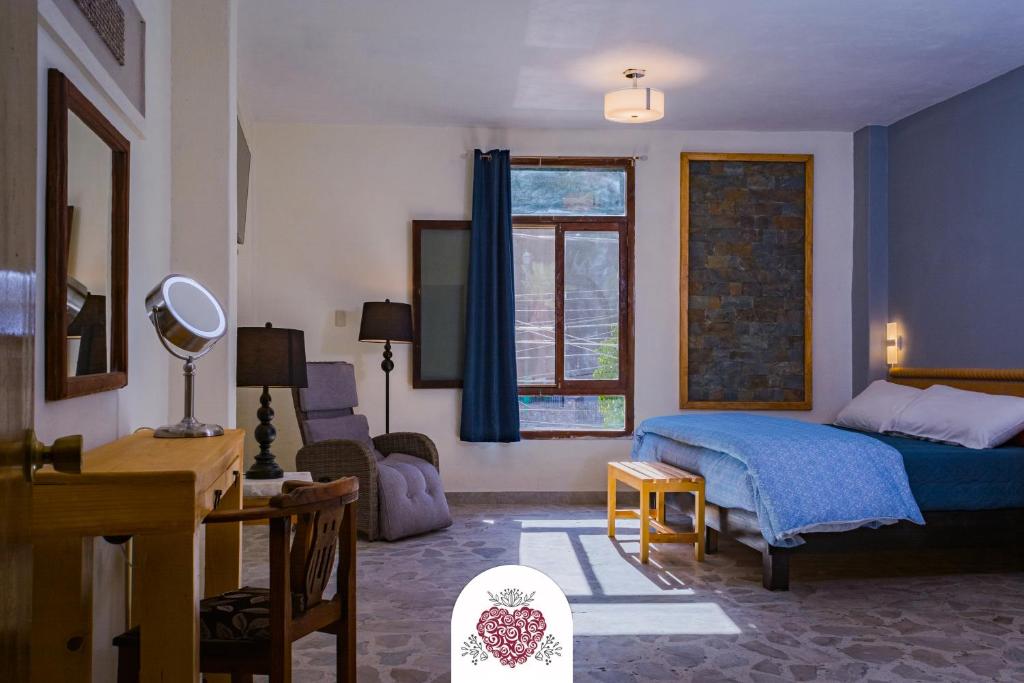 Hotel Corazón de Plata Centro في غواناخواتو: غرفة نوم مع سرير وغرفة معيشة