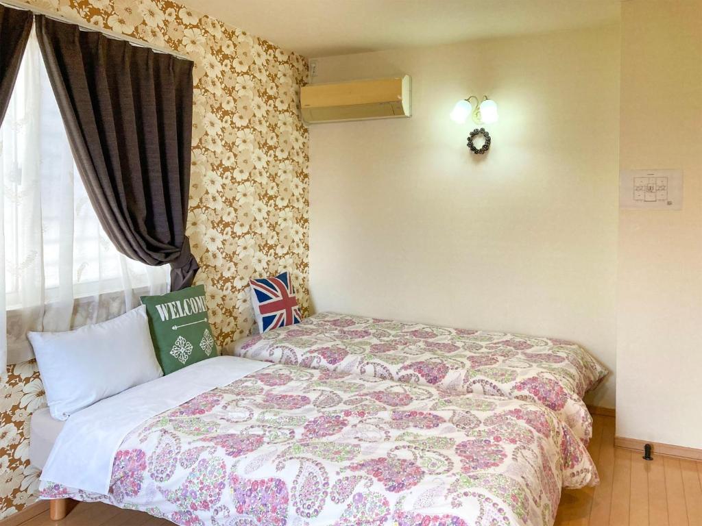 a bedroom with a bed with a floral bedspread at Pension Marinetown Aratta Vacation STAY 13299 in Gaja
