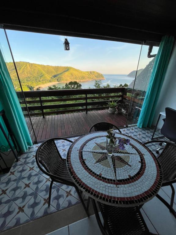 Loft com vista ao mar في ساو سيباستياو: طاولة وكراسي على شرفة مطلة