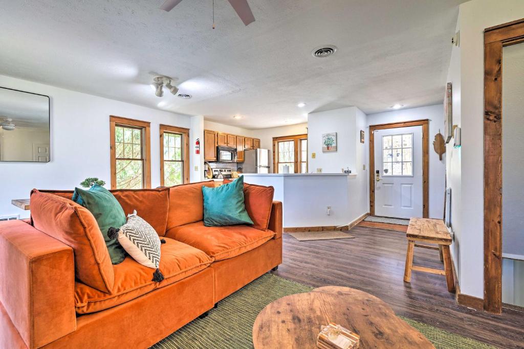 sala de estar con sofá naranja y mesa en Pocono Retreat, 1 Mi to State Park and Ski Access!, en Tannersville